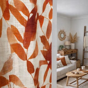 May include: A linen curtain with a large-scale leaf pattern in shades of orange and rust. The leaves are stylized and create a bold, naturalistic design. The curtain is in a living room setting, adding a warm, earthy tone to the space.