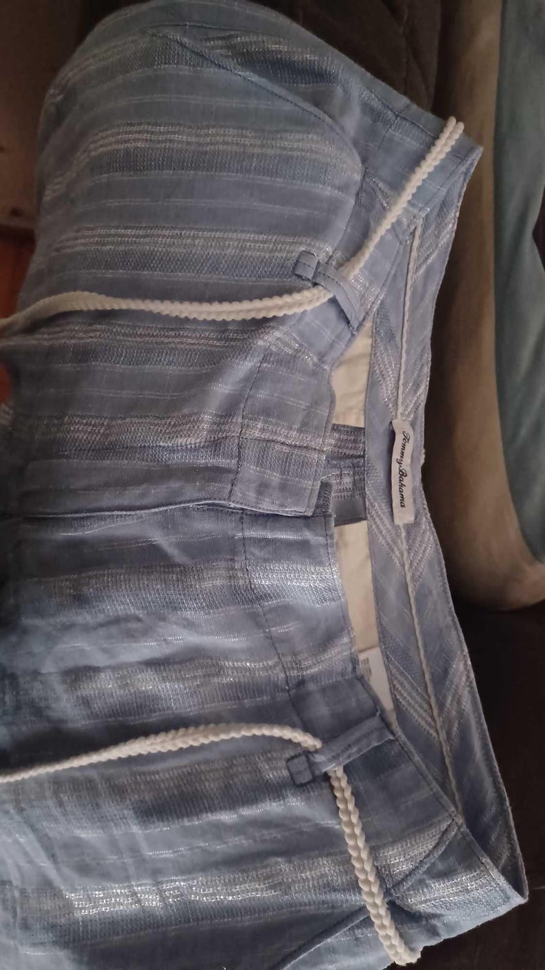Puede incluir: Pantalones cortos azul claro con un sutil estampado de rayas y un cord&oacute;n blanco. Los pantalones cortos tienen un ajuste relajado y una etiqueta "Tommy Bahama".