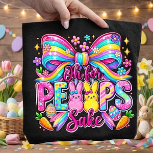 May include: Black tote bag with a colorful Easter design. The design includes a large bow, the phrase "Oh for Peeps Sake", Easter eggs, carrots, and two cartoon bunnies. The bag is held by a hand.