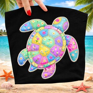 May include: Black tote bag featuring a colorful patchwork turtle design. The turtle is made of various pastel-colored fabric patches, each adorned with floral patterns. The edges of the turtle are outlined with white pearls.