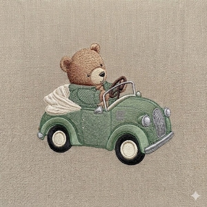 May include: Embroidered image of a teddy bear driving a vintage green car. The bear is wearing a green jacket and holding the steering wheel. The car has black tires and a white convertible top. The background is a neutral beige.