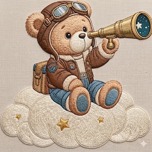 Puede incluir: Imagen bordada de un oso de peluche con casco y chaqueta de aviador marrón, sosteniendo un telescopio dorado. El oso está sentado en una nube blanca y esponjosa con estrellas doradas. El fondo es beige neutro.
