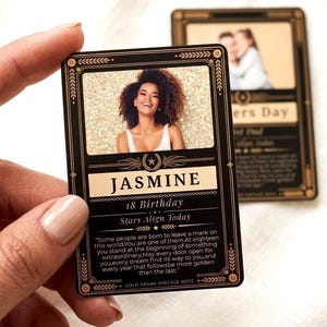 May include: A black and gold vintage-style card with a photo of a smiling woman named Jasmine. The card has the text "18 Birthday" and a quote. The card is held by a person.