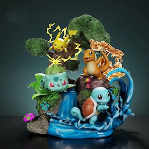 May include: A detailed figurine featuring four Pokémon characters: Pikachu, Charmander, Bulbasaur, and Squirtle. The scene includes a waterfall, stylized water effects, and foliage. The characters are in dynamic poses, with vibrant colors and intricate detailing.