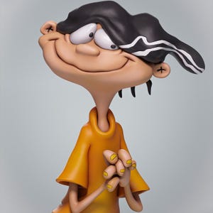 May include: A figurine of a cartoon character with a large smile, wearing an orange shirt and a black cap with white stripes. The character has large white eyes and yellow fingernails. The figurine is set against a light gray background.