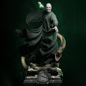 Puede incluir: Figura detallada de un personaje calvo con una túnica oscura, sosteniendo un objeto verde brillante. Una gran serpiente se enrosca alrededor de la figura, con la boca abierta. La estatua está sobre un fondo verde oscuro.