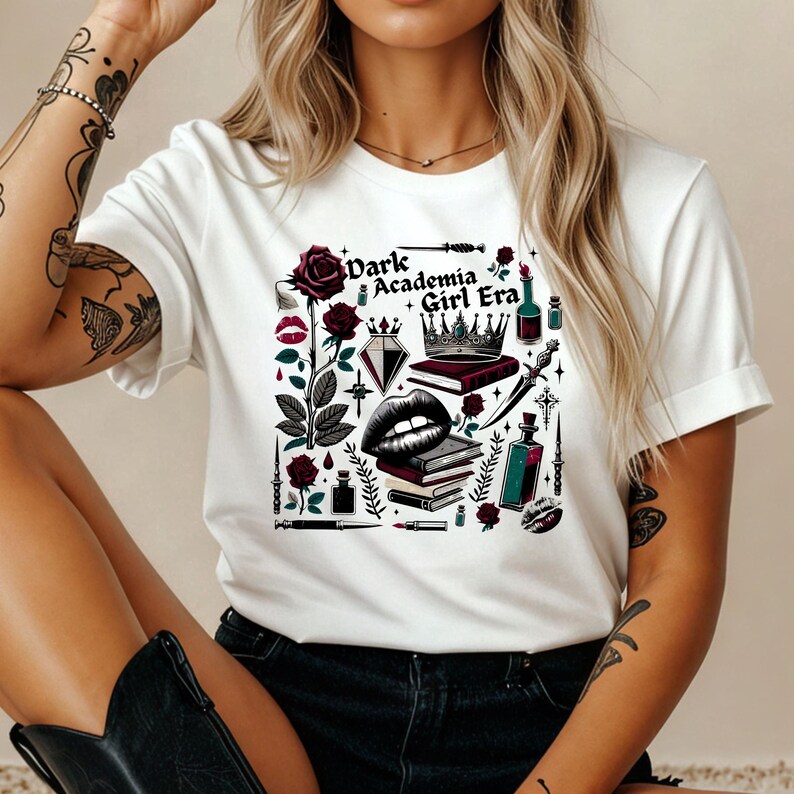 K&ouml;nnte beinhalten: Wei&szlig;es T-Shirt mit einem grafischen Design mit einer Rose, Lippen, einer Krone, B&uuml;chern und dem Text "Dark Academia Girl Era". Das Design enth&auml;lt dunkelrote, schwarze und gr&uuml;ne Elemente.