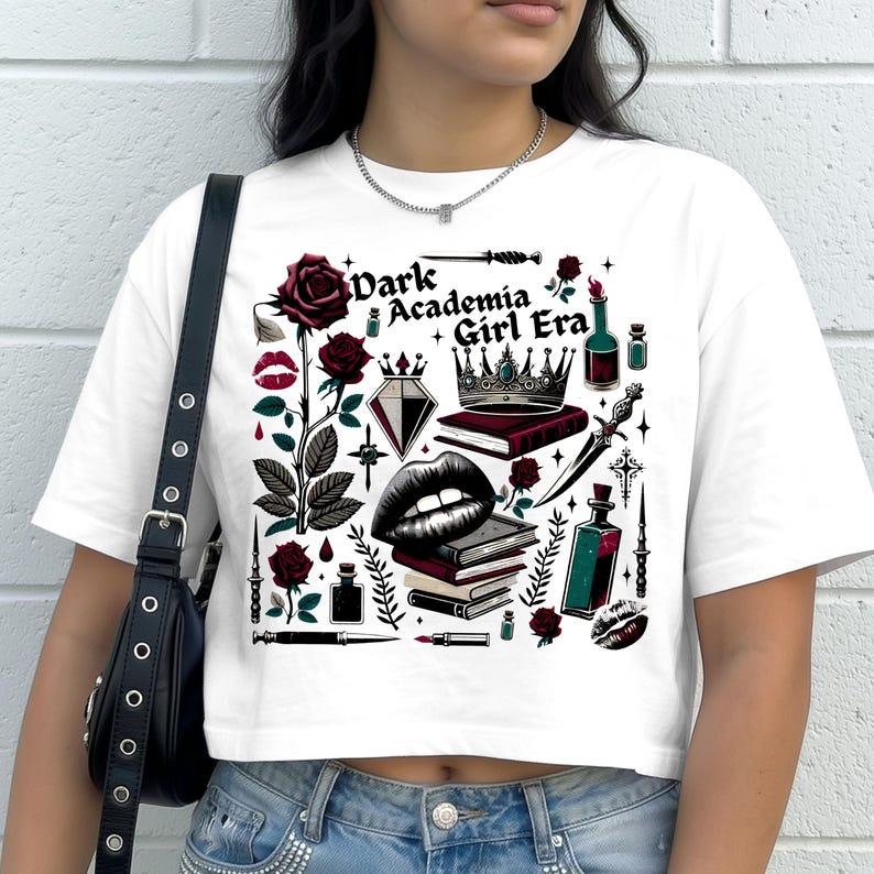 K&ouml;nnte beinhalten: Wei&szlig;es Crop-Top mit einem grafischen Design. Das Design zeigt den Text "Dark Academia Girl Era" zusammen mit Rosen, einer Krone, B&uuml;chern und gotischen Elementen in Schwarz, Rot und Wei&szlig;.