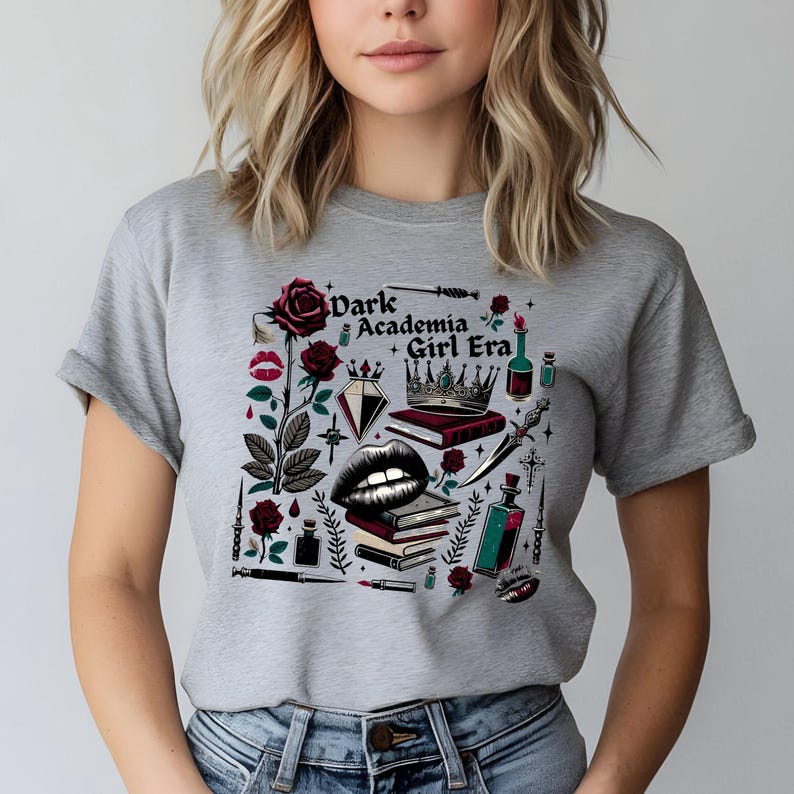 K&ouml;nnte beinhalten: Graues T-Shirt mit einem Grafikdesign mit dem Text "Dark Academia Girl Era". Das Design umfasst eine Rose, Lippen, B&uuml;cher, eine Krone und andere gotische Elemente in Rot, Schwarz und Wei&szlig;.