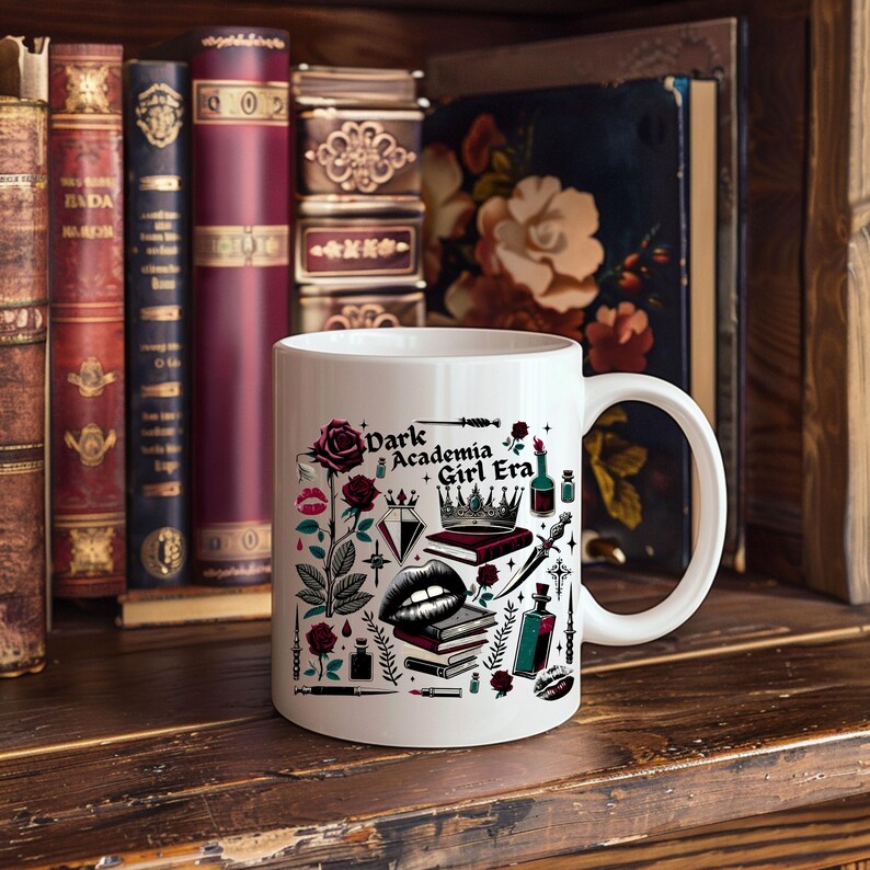 K&ouml;nnte beinhalten: Wei&szlig;e Keramiktasse mit dem Text "Dark Academia Girl Era" und Illustrationen von Rosen, B&uuml;chern und einer Krone. Die Tasse steht vor einer Sammlung antiker B&uuml;cher auf einem Holzregal.