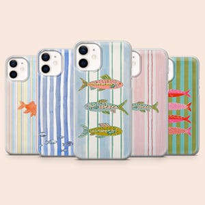 Può includere: Una collezione di custodie per telefoni con sfondi a righe colorate e illustrazioni di pesci. Le custodie presentano vari disegni di pesci in rosa, verde e giallo, con una copertura protettiva trasparente. Le custodie sono progettate per uno smartphone.