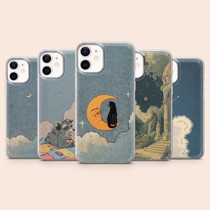 May include: A selection of phone cases featuring fantasy-themed artwork. Designs include a raccoon wearing headphones, a black cat on a crescent moon, and a building in a celestial landscape. The cases have a clear, protective design.