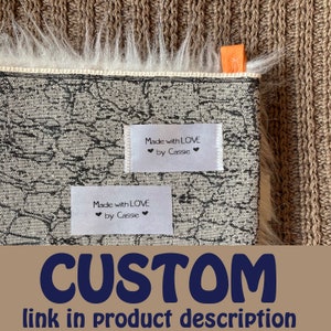 Puede incluir: Una etiqueta de tela blanca con texto negro que dice "Made with LOVE ❤ by Cassie ❤". La etiqueta est&aacute; unida a una tela estampada en blanco y negro.