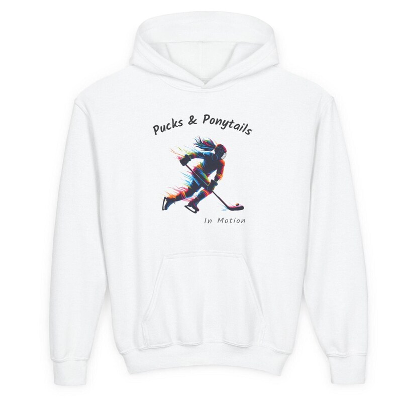 Puede incluir: Sudadera con capucha blanca con un gr&aacute;fico frontal. El gr&aacute;fico presenta una ilustraci&oacute;n colorida de una jugadora de hockey en movimiento, con el texto "Pucks & Ponytails" y "In Motion".