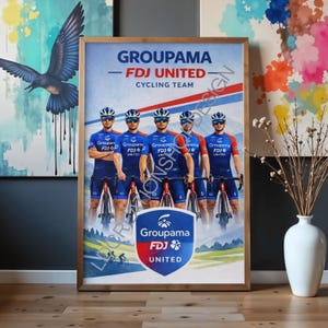 May include: Framed poster featuring the Groupama-FDJ United Cycling Team. The image shows five cyclists in blue and red uniforms, with the team's logo prominently displayed. The poster is in a wooden frame and is leaning against a wall.