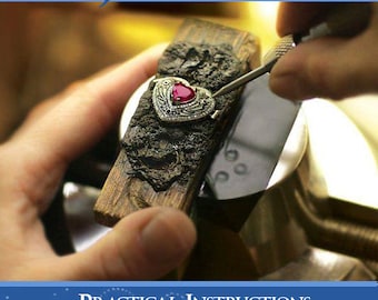 May include: A book titled "How To Make Jewelry: Practical Instructions From A Manufacturing Jeweler" by G.S. Overton. The cover features a close-up of a jeweler's hand setting a red gemstone in a heart-shaped ring.