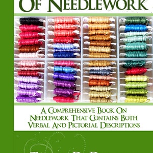 May include: A book titled "Encyclopedia of Needlework" by Therese De Dillmont. The cover features a variety of colorful embroidery floss spools in a plastic organizer.