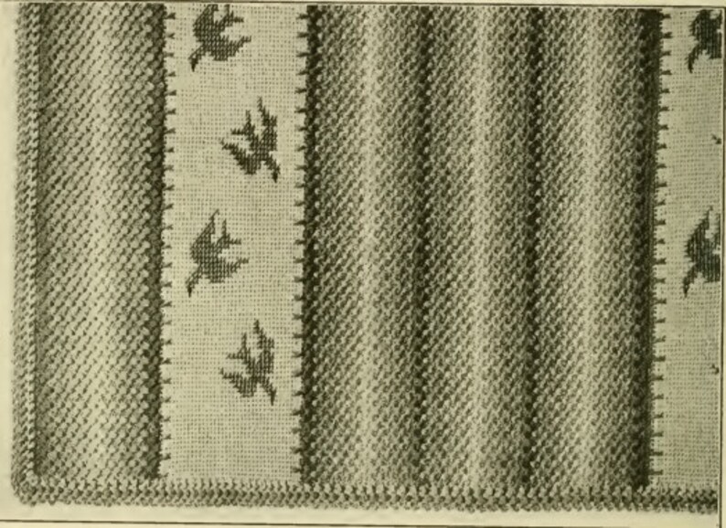 May include: A close-up of a woven fabric with a pattern of diagonal stripes in shades of gray. The fabric has a border with a repeating pattern of stylized birds.
