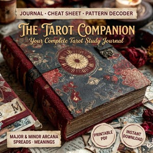 Puede incluir: Imagen detallada de un diario de tarot titulado "The Tarot Companion". La portada es azul oscuro con patrones florales rojos y un diseño circular central. El diario incluye el texto "Journal, Cheat Sheet, Pattern Decoder" y "Major & Minor Arcana, Spreads, Meanings."