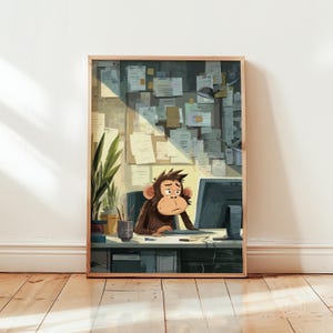 Op de afbeelding: Een ingelijste illustratie toont een bruine aap die aan een bureau zit en met een gestreste uitdrukking naar een computerscherm kijkt. De kantooromgeving omvat een prikbord, planten en een bureaulamp. Het kunstwerk zit in een houten lijst.