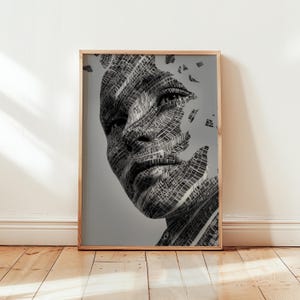 Könnte beinhalten: Ein gerahmter Kunstdruck mit einem Graustufenporträt eines menschlichen Gesichts. Das Bild besteht aus einem Netzwerk von Linien, wodurch ein fragmentierter, abstrakter Effekt entsteht. Das Kunstwerk wird in einem Holzrahmen präsentiert.