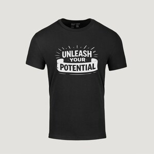 May include: Black t-shirt with the white text "UNLEASH YOUR POTENTIAL" in a stylized design. The text is centered on the front of the shirt. The shirt has short sleeves and a crew neck.
