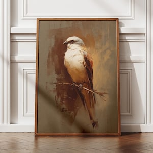 May include: A framed art print depicting a bird perched on a branch. The painting features a bird with white, brown, and tan feathers. The artwork is set against a muted brown background and framed in a wooden frame.