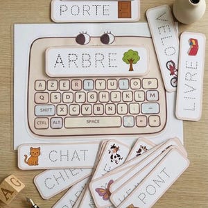 Peut inclure: Jeu éducatif avec un tableau d'apprentissage en forme de clavier affichant le mot "ARBRE" et une image d'arbre. Comprend des cartes flash avec des mots comme "CHAT" et "LION", ainsi que des illustrations. Parfait pour l'apprentissage précoce.