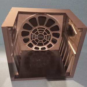 Könnte beinhalten: Ein beigefarbenes, geometrisches Diorama mit einem großen kreisförmigen Fenster und kleineren rechteckigen Fenstern. Der Innenraum hat einen dunklen Boden und abgewinkelte Wandstützen. Das Design erinnert an einen Raumschiffinnenraum.