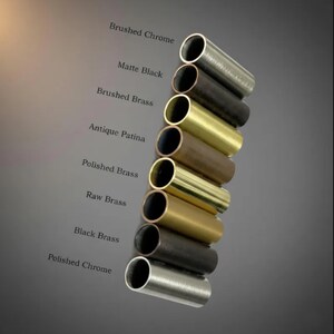 May include: An assortment of cylindrical metal tubes in various finishes, including Brushed Chrome, Matte Black, and Polished Brass. The image displays a range of colors and textures, with labels identifying each finish. The tubes are arranged diagonally.