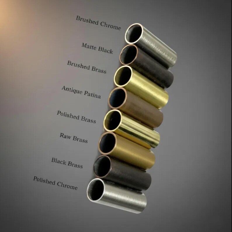 May include: An assortment of cylindrical metal tubes in various finishes, including Brushed Chrome, Matte Black, and Polished Brass. The image displays a range of colors and textures, with labels identifying each finish. The tubes are arranged diagonally.