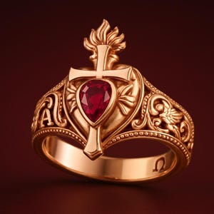 Può includere: Anello color oro con un design a croce e una gemma rossa a forma di goccia. L'anello presenta dettagli ornati, tra cui motivi floreali e a volute, e le lettere greche alfa e omega.