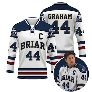 May include: White hockey jersey with navy blue and red accents. The jersey features the name "GRAHAM" and the number "44" on the back. The front displays "BRIAR" and "44". A smaller image of the jersey is also shown.