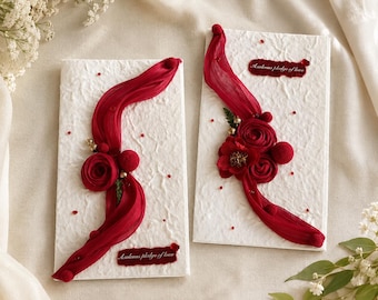 Libros de votos matrimoniales con diseño floral rojo, tarjetas de promesas nupciales hechas a mano para guardar como recuerdo de la ceremonia.