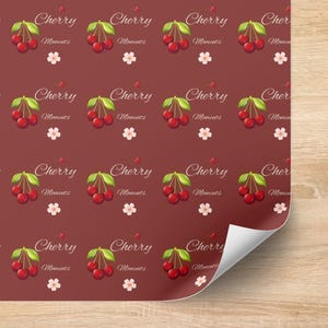 May include: A maroon-colored wrapping paper with a repeating pattern of cherries, green leaves, and white flowers. The word "Cherry" and "Moments" are written in a cursive font.