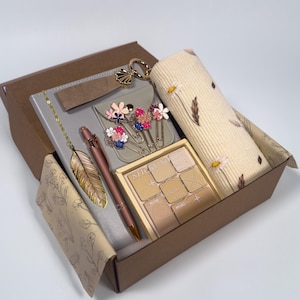 May include: A set of three ceramic mugs with a speckled, matte finish. The mugs are in shades of cream, light grey, and dark grey. Each mug has a simple, minimalist design, ideal for coffee or tea.