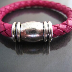 May include: A pink braided leather bracelet with a silver magnetic clasp.