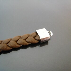May include: A brown leather braided bracelet with a silver clasp.