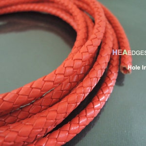 Puede incluir: Primer plano de un cordón de cuero trenzado de color rojo brillante. El cordón está tejido con un agujero que atraviesa el centro. El texto "HEAEDGES Hole Inside" es visible en la imagen.