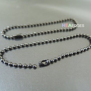 May include: A close-up shot of two dark gray ball chains, one open and one closed. The chains are made of small, evenly spaced metal balls. The text "HEA EDGES" is visible in the background.