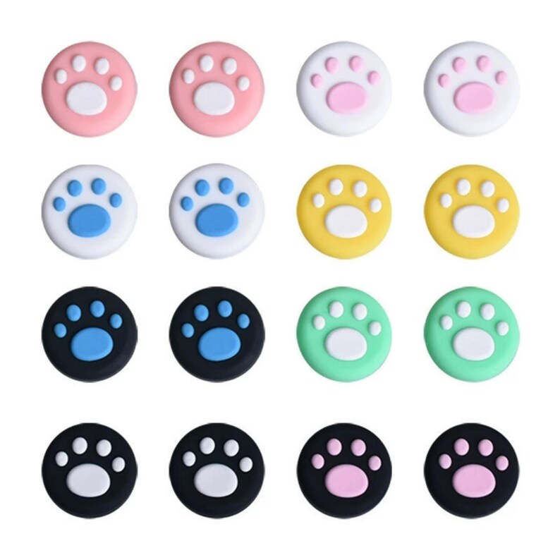 Puede incluir: Un conjunto de diecis&eacute;is agarres de pulgar coloridos para mandos de juegos. Los agarres son redondos y presentan un dise&ntilde;o de huella de pata. Los colores incluyen rosa, blanco, azul, amarillo, negro y verde. Las huellas de pata son de colores contrastantes.