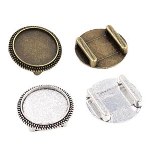 May include: Two sets of round metal tray bases for crafting. One set is antique brass with a textured edge, the other is silver with a textured edge.