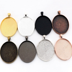 Puede incluir: Ocho bandejas redondas para colgantes en varios colores, incluyendo oro, plata, negro, cobre, bronce y oro rosa. Las bandejas tienen una superficie lisa ligeramente texturizada y un bucle en la parte superior para colgar.