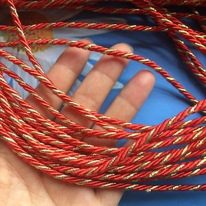 May include: Red and gold braided cord, a decorative trim for crafts and home decor projects.