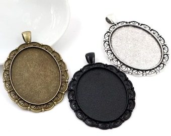 May include: Three oval-shaped pendant trays with ornate edges. The trays are silver, black, and bronze.