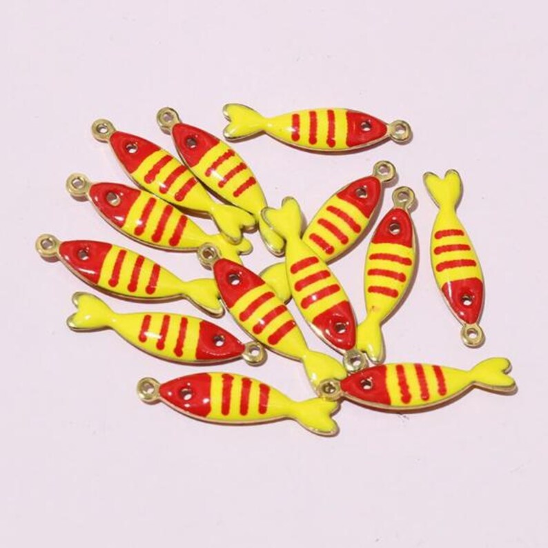May include: A selection of yellow and red fish-shaped charms with gold loops, perfect for jewellery making. The charms feature red heads and tails, yellow bodies, and red stripes. Ideal for crafting projects.