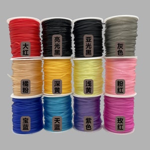 May include: Twelve spools of colorful elastic cord, each with a label in Chinese characters. The colors include red, pink, orange, yellow, light blue, dark blue, purple, gray, and black.