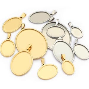 May include: An assortment of oval pendant trays in gold and silver. The trays are of various sizes and have a loop at the top for attaching to a chain. The pendants are blank, ready for customisation with resin, photos, or other embellishments.