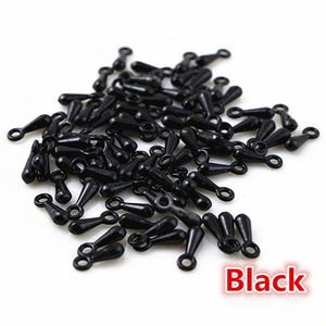 May include: A pile of small, black plastic safety eyes for crafts. Each eye has a rounded head, a tapered body, and a small loop at the end. The word "Black" is in a red box in the lower right corner.