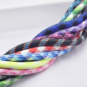 May include: A collection of braided nylon cords featuring a variety of vibrant colors and patterns, including solid neon yellow, black with blue accents, red and white checkered, purple, pink, and green geometric designs woven into the rope.